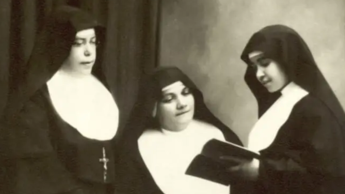 La beata Eusebia Palomino, a la derecha de la foto, lee un libro ante dos hermanas salesianas.