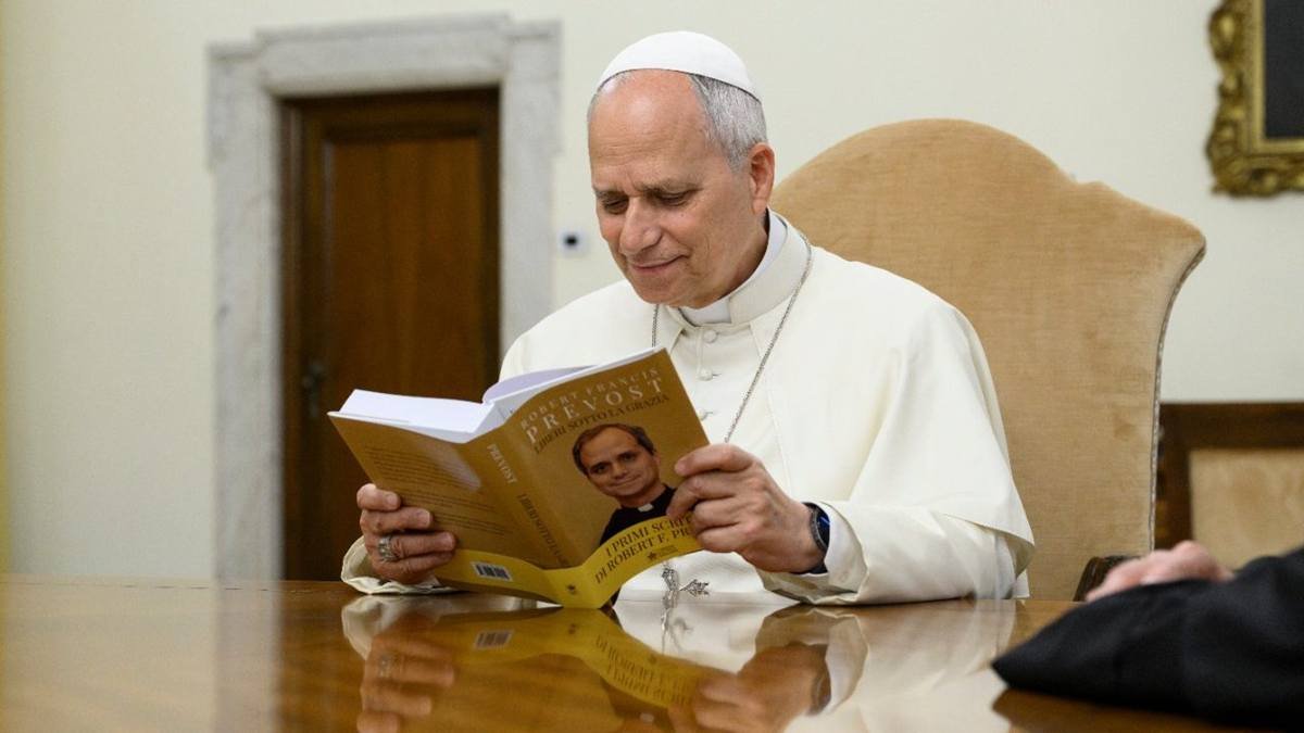 León XIV lee un libro publicado en el Vaticano que recoge sus mejores discursos como prior general de los agustinos.