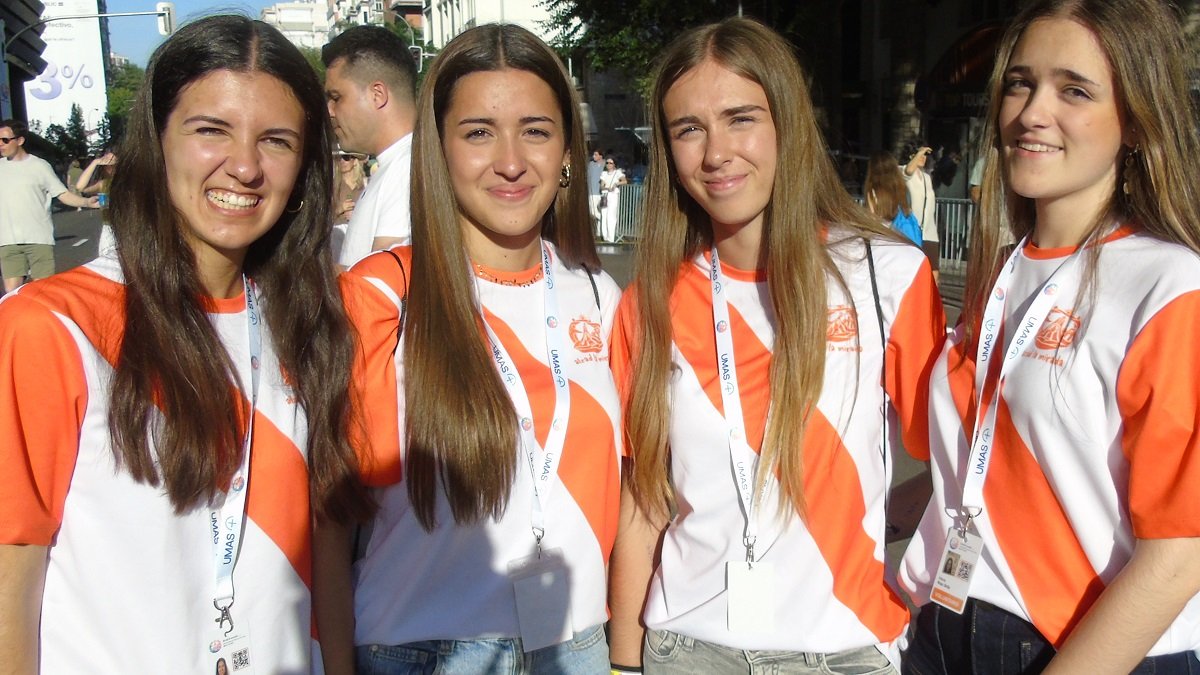 Cuatro jóvenes voluntarias de la Obra de la Iglesia, llegadas de distintas ciudades para el servicio de orden, revisando QRs... saben de música católica