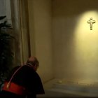 Un cardenal reza ante la tumba de Francisco, con su nombre y una rosa blanca depositada encima.