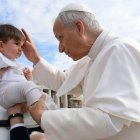 León XIV bendice a un niño durante su recorrido entre los fieles presentes en la Plaza de San Pedro.