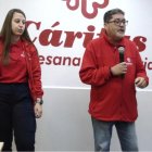 Juan José Gómez, responsable del centro CEDIA, y la psicóloga María Bianca, junto al cartel de la visita papal; León visitará el centro