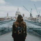Uma mulher contempla a Catedral de São Paulo em Londres. A coexistência de uma grandiosa catedral histórica com a cidade contemporânea ilustra o debate em torno do cristianismo, da Europa e do Ocidente.