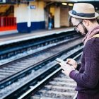 Este hipster com um iPhone pode estar rezando a Liturgia das Horas enquanto espera o trem - foto de Clem Onojeghuo, no Unsplash