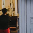 Una mujer a la entrada de una capilla, quizá orando sin entrar