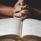 Un hombre rezando con la Biblia.