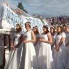 Chicas vestidas de novia llevan la imagen de la Virgen Dormida el día de la Asunción en Borek Stary, sur de Polonia