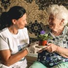 Una voluntaria de Caritas Ucrania visita a una anciana en la bombardeada Járkov en 2025