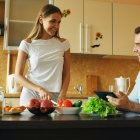 Una chica empieza a cocinar, distraída por un chico guapo... pero en España, según Fundación SM 2026, los chicos hacen más tareas domésticas que ellas