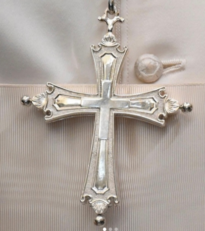 La cruz pectoral se diferencia de la anterior por ser esta de plata