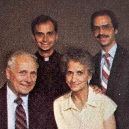 Robert, de sacerdote, junto a uno de sus dos hermanos y a sus padres.