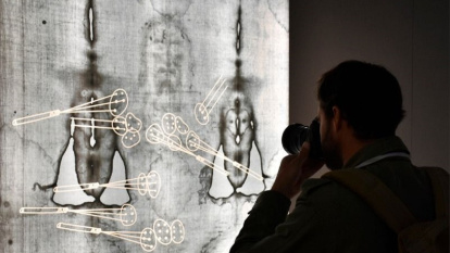 Un fotógrafo ante un negativo a tamaño real de la imagen que aparece en la Sábana Santa de Turín, en Salamanca, en 2022