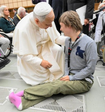 León XIV saluda a un joven discapacitado.