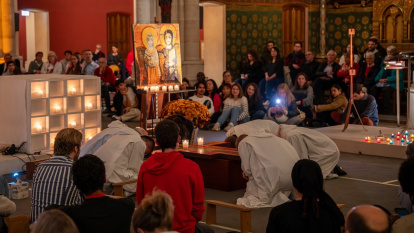 Hermanos de Taizé y jóvenes en una oración preparatoria en noviembre de 2025 en París, con iconos y velas